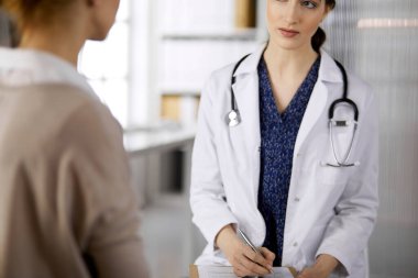 Doktor ve hasta klinikte otururken sağlık muayenesini tartışıyorlar. Hastanede mükemmel bir tıbbi hizmet. Tıp konsepti