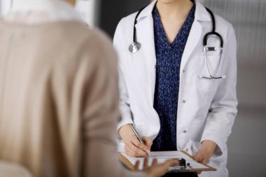 Doktor ve hasta klinikte otururken sağlık muayenesini tartışıyorlar. Hastanede mükemmel bir tıbbi hizmet. Tıp konsepti