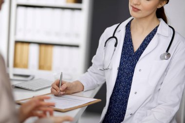 Doktor ve hasta klinikte otururken sağlık muayenesini tartışıyorlar. Hastanede mükemmel bir tıbbi hizmet. Tıp konsepti