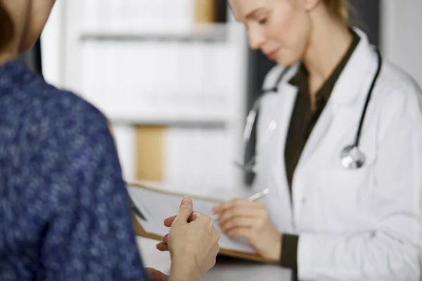 Medico e paziente discutere esame di salute in corso mentre seduto in clinica. Servizio medico perfetto in ospedale. Concetto di medicina — Foto Stock