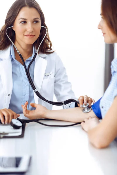 Doutor com um estetoscópio na mão examinando sua paciente feminina. Conceitos de saúde, cardiologia e medicina — Fotografia de Stock