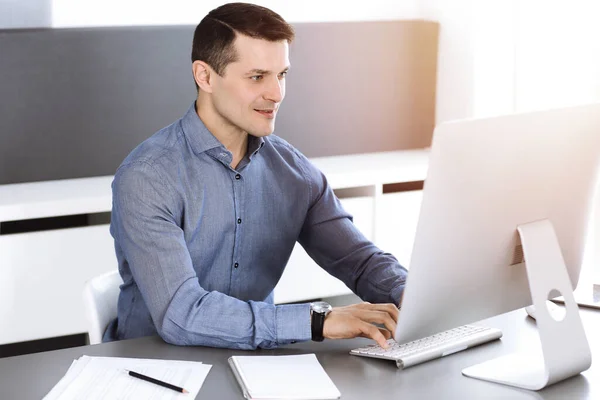 Geschäftsmann arbeitet mit Computer in modernem, sonnigen Büro. Kopfschuss eines männlichen Unternehmers oder Firmendirektors am Arbeitsplatz. Geschäftskonzept — Stockfoto