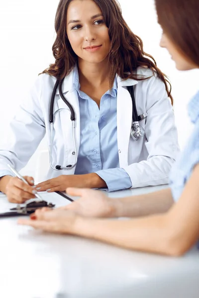 Docteur et patient parlent assis au bureau. Le médecin parle d'un mode de vie sain. Concept de soins de santé, de médecine et de services aux patients — Photo