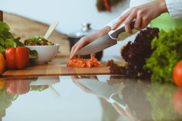 Manos humanas desconocidas cocinando en la cocina. Mujer cortando tomates rojos. Comida saludable y concepto de comida vegetariana —  Fotos de Stock