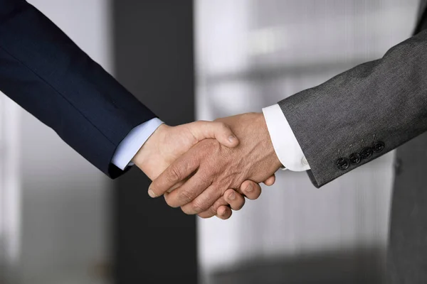 オフィスのビジネスの人々が立って握手、クローズアップに適しています。ビジネスコミュニケーションの概念。握手とマーケティング — ストック写真