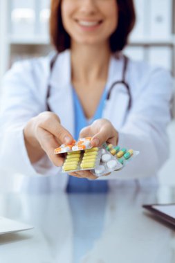 Kadın doktor, elinde farklı tablet kabarcıkları olan el çantası tutuyor. Hayat kurtarma servisi, yasal eczane, ilaç reçetesi, kan basıncı, hastalık iyileştirme konsepti