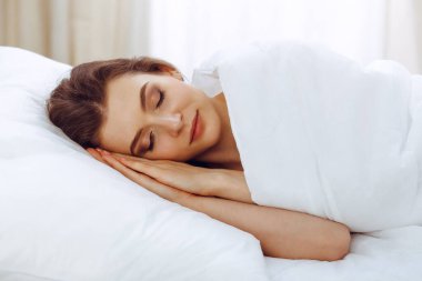 Yatağında yatarken uyuyan güzel bir genç kadın. Aktif yaşam için keyifli ve dinlenme kavramı