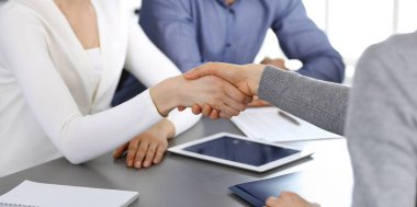Bir grup iş adamı modern ofiste soruları tartıştıktan sonra el sıkışıyor. El sıkışın, yakın plan. İş konseptinde takım çalışması, ortaklık ve anlaşma