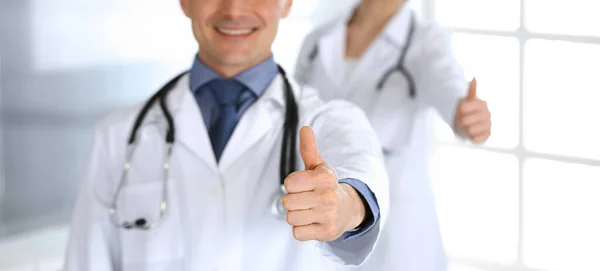 Egy csapat orvos mutogatja a hüvelykujját. Tökéletes orvosi ellátás a klinikán. Boldog jövőt az orvostudomány és az egészségügy területén — Stock Fotó
