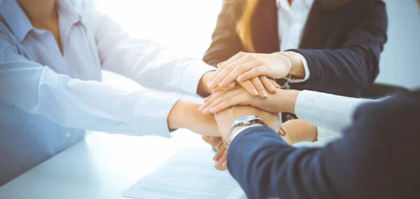 Geschäftsteam zeigt im sonnigen Büro Geschlossenheit mit den Händen. Gruppe von Menschen, die sich die Hände reichen und das Konzept der Freundschaft, Teamarbeit und Partnerschaft repräsentieren — Stockfoto