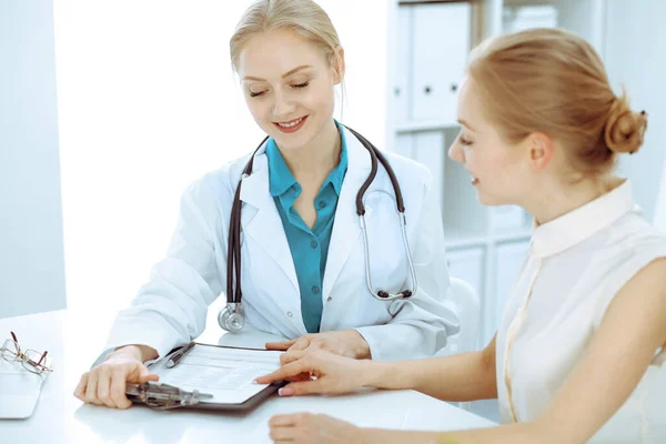 Médico e paciente conversando no consultório do hospital enquanto sentados na mesa. Cuidados de saúde e atendimento ao cliente em medicina — Fotografia de Stock