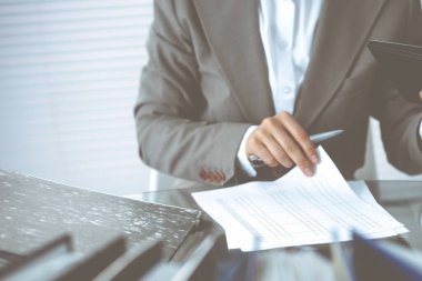 Muhasebeci kadın ya da mali müfettiş rapor hazırlıyor, hesaplıyor ya da dengeyi kontrol ediyor, yakın plan. İş, denetim veya vergi kavramları