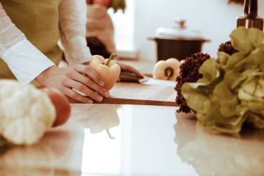 Mutfakta pişen bilinmeyen insan elleri. Kadın sebze salatasıyla meşgul. Sağlıklı yemek ve vejetaryen gıda konsepti.