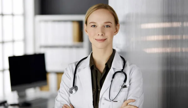 Allegro sorridente medico donna in piedi in clinica. Ritratto di donna medico amichevole. Servizio medico perfetto in ospedale. Concetto di medicina — Foto Stock