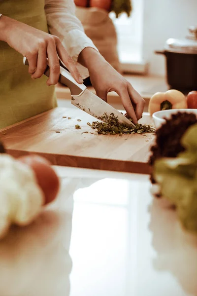 Mãos humanas desconhecidas a cozinhar na cozinha. A mulher está ocupada com salada de legumes. Refeição saudável e conceito de comida vegetariana — Fotografia de Stock