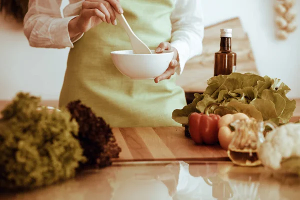 Onbekende mensenhanden die koken in de keuken. Vrouw is bezig met groentesalade. Gezonde maaltijd en vegetarisch voedselconcept — Stockfoto
