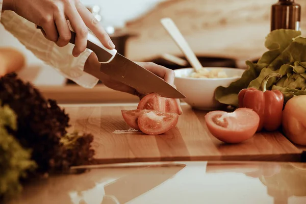 모르는 인간 손으로 부엌에서 요리하고 있어. 빨간 토마토를 썰고 있는 여자. 건강에 좋은 식사와 채식 식품의 개념 — 스톡 사진