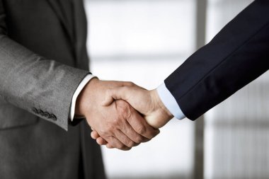 Ofisteki iş adamları ayakta ve el sıkışıyorlar, yakın plan. İş iletişimi kavramı. El sıkışma ve pazarlama