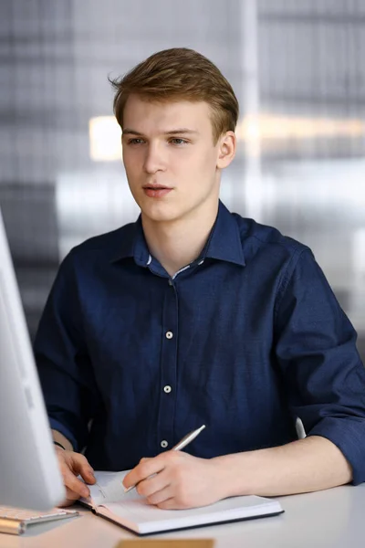 Jeune homme d'affaires blond travaillant avec l'ordinateur. Démarrage d'entreprise signifie travailler dur et hors du temps pour la réussite — Photo