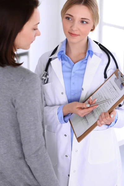 Young woman doctor and patient at medical examination at hospital office. Blue color blouse of therapist looks good. Medicine and healthcare concept — Stock Photo, Image