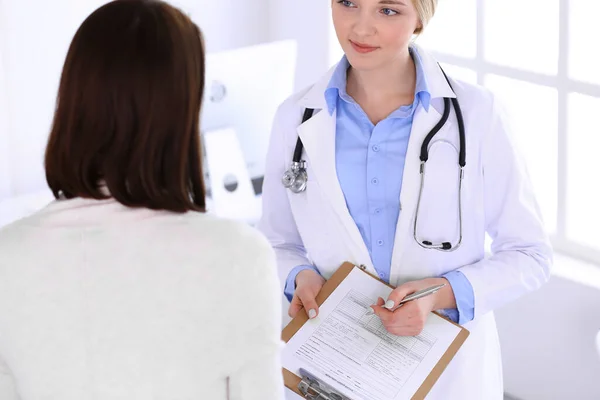 Jeune femme médecin et patiente à l'examen médical au bureau de l'hôpital. Blouse de couleur bleue de thérapeute semble bon. Médecine et concept de santé — Photo