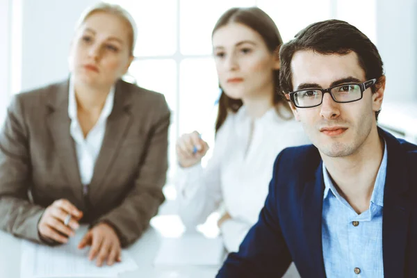 Group of business people discussing questions at meeting in modern office. Headshot of businessman at negotiation. Teamwork, partnership and business concept — Stock Photo, Image