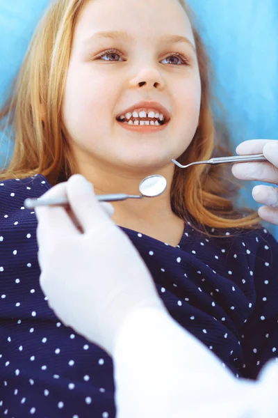 Menina sentada na cadeira dentária com a boca aberta durante o check-up oral, enquanto médico. Consulta ao dentista. Conceito de medicina. Foto tonificada — Fotografia de Stock