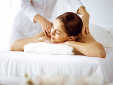 Güzel esmer kadın gözleri kapalı sırt masajından hoşlanıyor. Spa ve tıp konsepti
