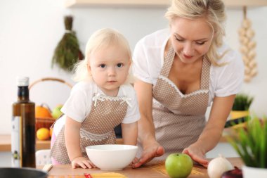 Mutfakta yemek pişiren mutlu anne ve küçük kız. Birlikte vakit geçirmek, aile eğlencesi konsepti.