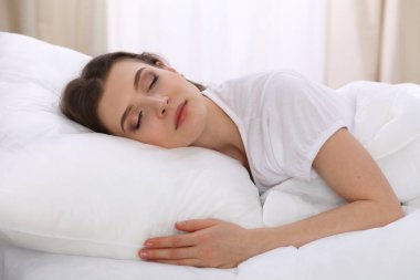 Yatağında yatarken uyuyan güzel bir genç kadın. Aktif yaşam için keyifli ve dinlenme kavramı