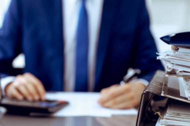 Dosyalarda işadamı ya da muhasebeci tarafından işleme konmayı bekleyen dosyalar var. Muhasebe bütçesi. Denetim, sigorta ve iş konsepti