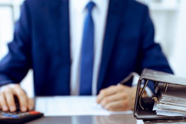 Dosyalarda işadamı ya da muhasebeci tarafından işleme konmayı bekleyen dosyalar var. Muhasebe bütçesi. Denetim, sigorta ve iş konsepti