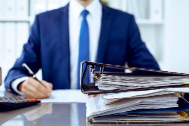 Dosyalarda işadamı ya da muhasebeci tarafından işleme konmayı bekleyen dosyalar var. Muhasebe bütçesi. Denetim, sigorta ve iş konsepti