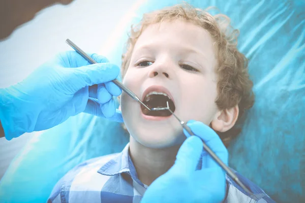 Lekarz i cierpliwe dziecko. Chłopak bada zęby u dentysty. Koncepcja medycyny, opieki zdrowotnej i stomatologii — Zdjęcie stockowe