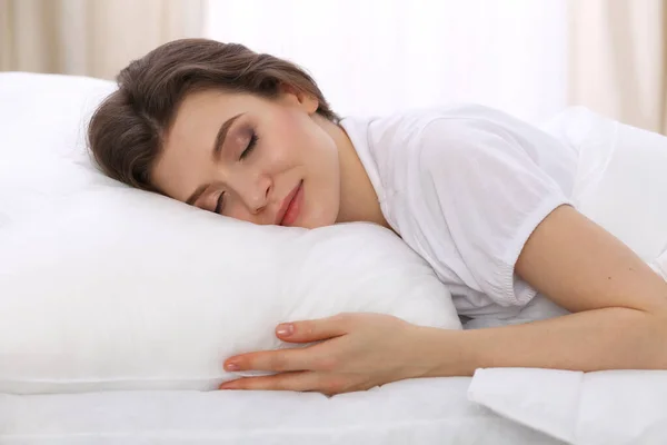 Красивая молодая женщина спит, лежа в постели. Концепция восстановления приятного и отдыха для активной жизни — стоковое фото