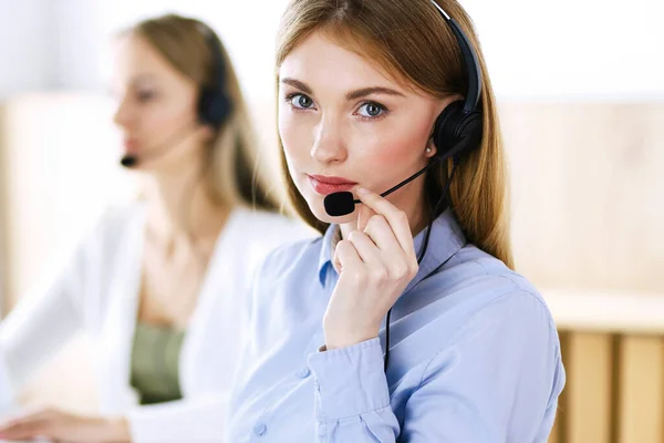 Portret van callcenter operator aan het werk. Groep mensen in een headset klaar om klanten te helpen. Bedrijfsconcept Stockfoto