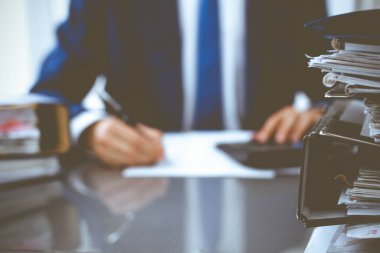 Dosyalarda işadamı ya da muhasebeci tarafından işleme konmayı bekleyen dosyalar var. Muhasebe bütçesi. Denetim, sigorta ve iş konsepti