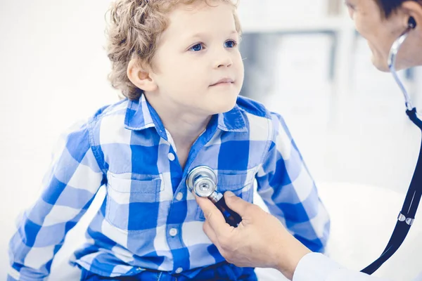 Arzt und geduldiges Kind. Arzt untersucht kleinen Jungen. Regelmäßiger Arztbesuch in der Klinik. Medizin und Gesundheitskonzept — Stockfoto