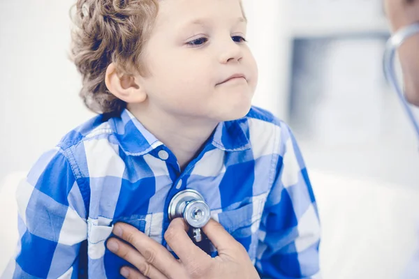 Arzt und geduldiges Kind. Arzt untersucht kleinen Jungen. Regelmäßiger Arztbesuch in der Klinik. Medizin und Gesundheitskonzept — Stockfoto