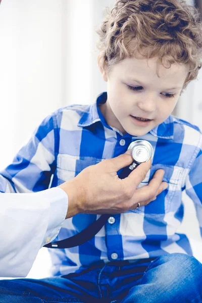 Γιατρός και υπομονετικό παιδί. Ο γιατρός εξετάζει το αγοράκι. Τακτική ιατρική επίσκεψη στην κλινική. Ιατρική και υγειονομική περίθαλψη — Φωτογραφία Αρχείου