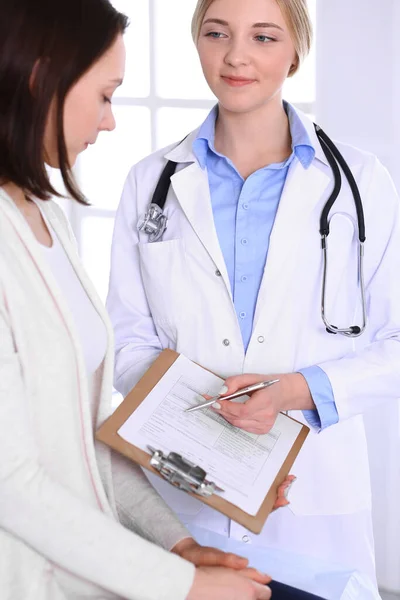 Young woman doctor and patient at medical examination at hospital office. Blue color blouse of therapist looks good. Medicine and healthcare concept — Stock Photo, Image