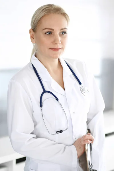 Dospělá doktorka stojící přímo v nemocniční kanceláři, portrét. Perfektní lékařská služba na klinice. Medicína a zdravotní koncepce — Stock fotografie