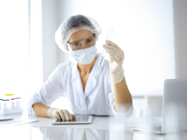 Professzionális női tudós védőszemüvegben, kémcsövet kutatva reagensekkel a laboratóriumban. Az orvostudomány és a kutatás fogalma — Stock Fotó