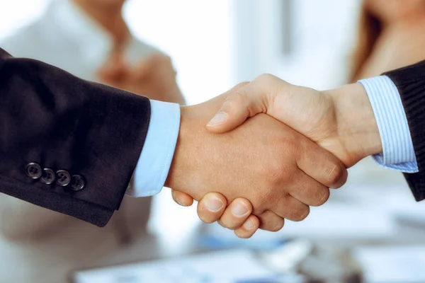 Gli uomini d'affari si stringono la mano mentre i loro colleghi applaudono e applaudono. Gruppo di uomini e donne d'affari sconosciuti nel moderno ufficio bianco. Lavoro di squadra di successo, partnership e stretta di mano — Foto Stock