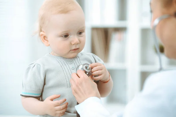 Doktor ve hasta hastanede. Küçük kız steteskopla doktor tarafından muayene ediliyor. Tıp konsepti — Stok fotoğraf