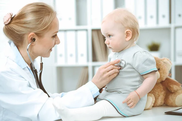 Doctor and patient in hospital. Little girl is being examined by doctor with stethoscope. Medicine concept