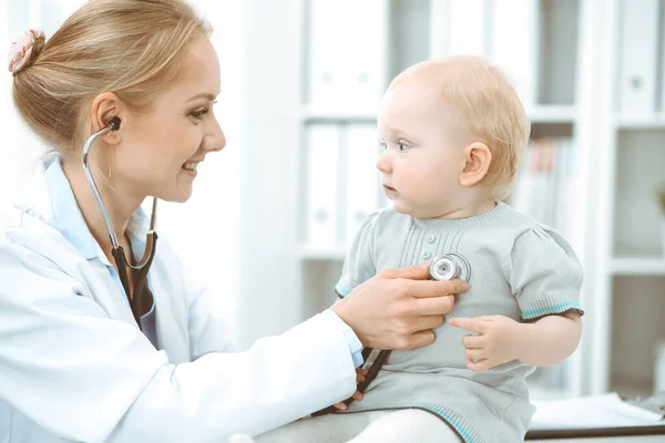 Médico y paciente en el hospital. La niña está siendo examinada por un médico con estetoscopio. Concepto de medicina —  Fotos de Stock