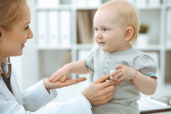 Médico y paciente en el hospital. La niña está siendo examinada por un médico con estetoscopio. Concepto de medicina — Foto de Stock