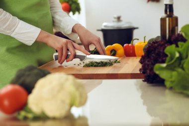 Mutfakta pişen bilinmeyen insan elleri. Kadın sebze salatasıyla meşgul. Sağlıklı yemek ve vejetaryen gıda konsepti.