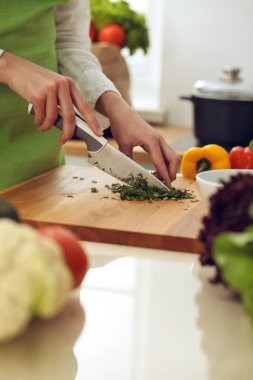 Mutfakta pişen bilinmeyen insan elleri. Kadın sebze salatasıyla meşgul. Sağlıklı yemek ve vejetaryen gıda konsepti.